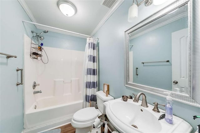 full bath with a sink, shower / tub combo with curtain, toilet, visible vents, and ornamental molding