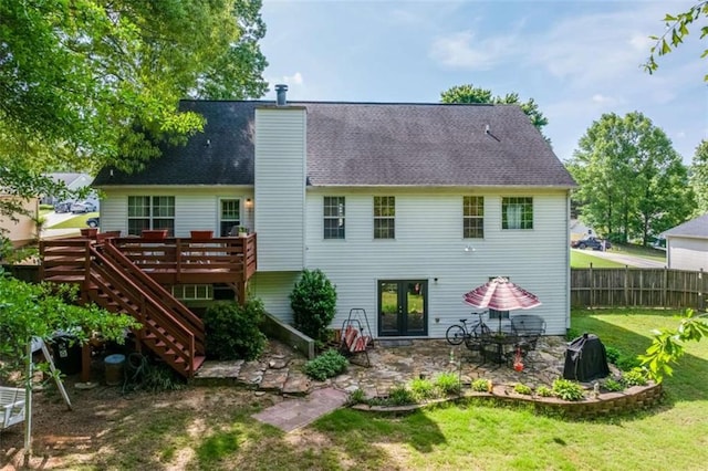 back of house featuring french doors, a lawn, a wooden deck, stairway, and fence