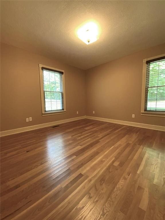 spare room with hardwood / wood-style floors and a textured ceiling