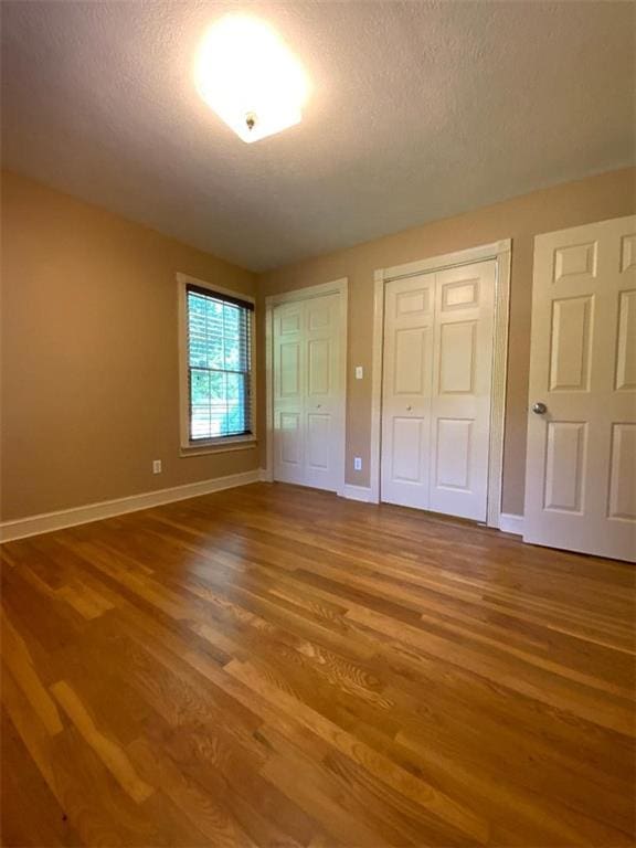 unfurnished bedroom featuring wood-type flooring and a textured ceiling