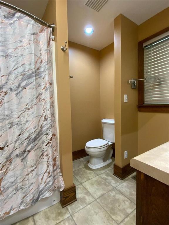 bathroom with vanity, curtained shower, and toilet