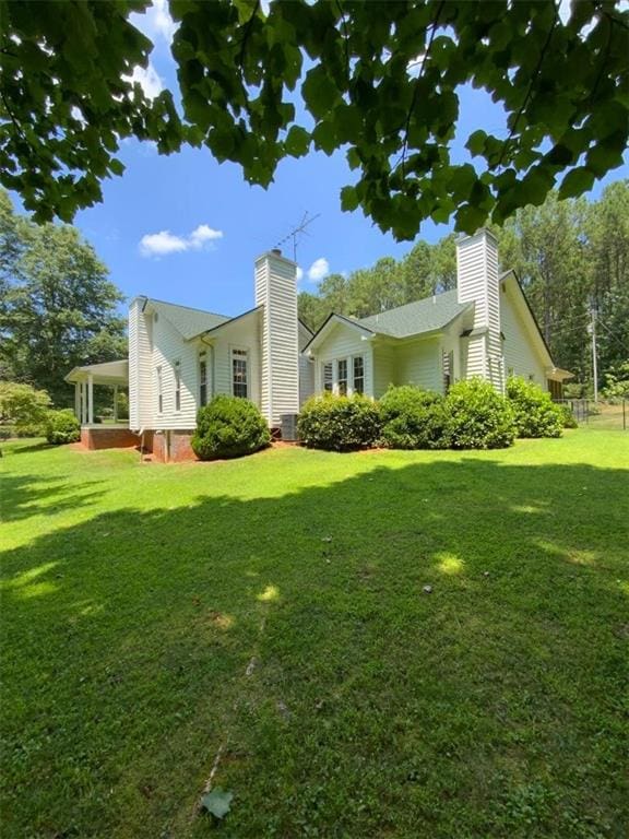 view of side of home with a yard