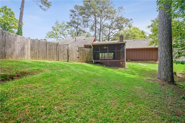 view of yard with a sunroom and a fenced backyard