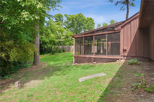 view of yard with fence and a sunroom