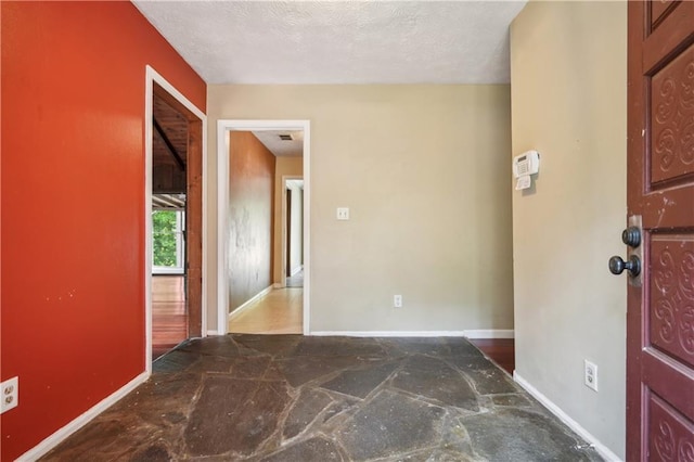 entryway featuring baseboards and stone floors