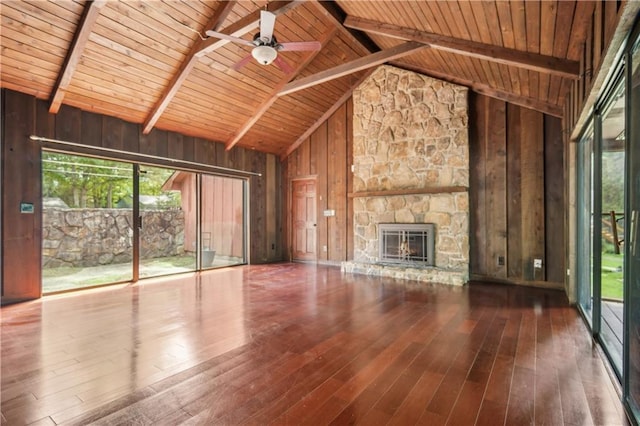 unfurnished living room featuring ceiling fan, beam ceiling, wood walls, wood ceiling, and hardwood / wood-style flooring