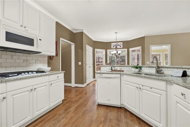 kitchen with white cabinetry, white appliances, plenty of natural light, and pendant lighting