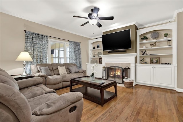 living room with crown molding, ceiling fan, and light wood-type flooring