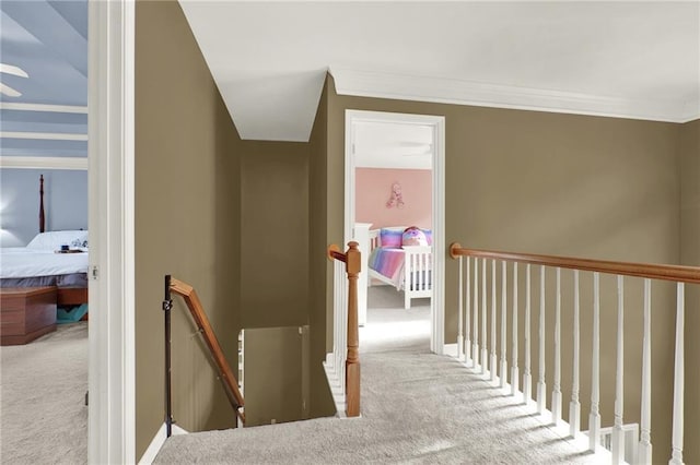 hallway with crown molding and light colored carpet