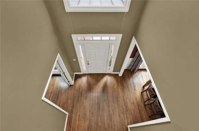 foyer featuring a towering ceiling and dark hardwood / wood-style floors