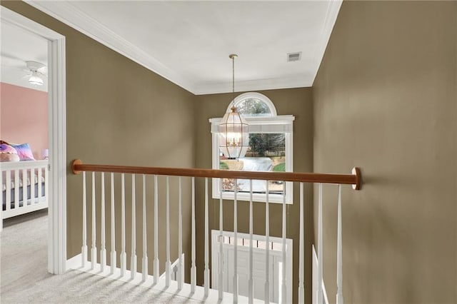 staircase featuring crown molding, ceiling fan with notable chandelier, and carpet floors