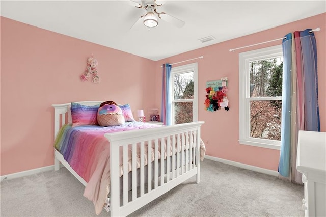 bedroom with multiple windows, light carpet, and ceiling fan