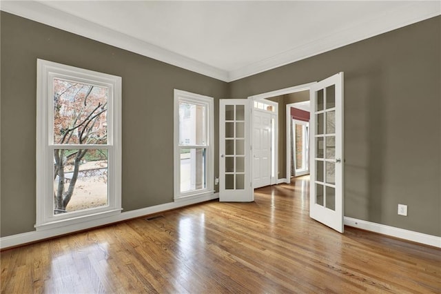 unfurnished room featuring crown molding, light hardwood / wood-style flooring, and french doors