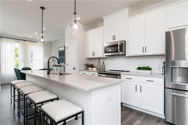 kitchen featuring a sink, decorative backsplash, a kitchen bar, and appliances with stainless steel finishes