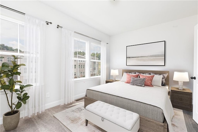 carpeted bedroom with baseboards and multiple windows