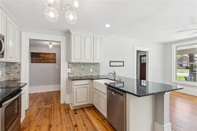 1382 6th Ave, Auburn, GA 30011 - kitchen with appliances with stainless steel finishes, a sink, a peninsula, light wood-style flooring, and recessed lighting
