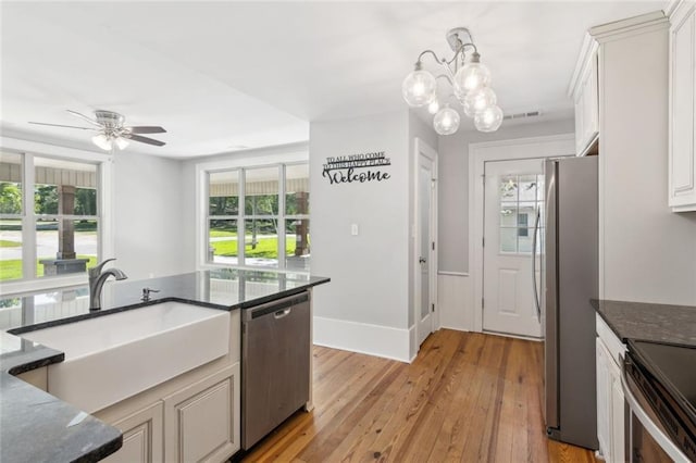 1382 6th Ave, Auburn, GA 30011 - kitchen with appliances with stainless steel finishes, a sink, light wood-style flooring, dark stone countertops, and pendant lighting