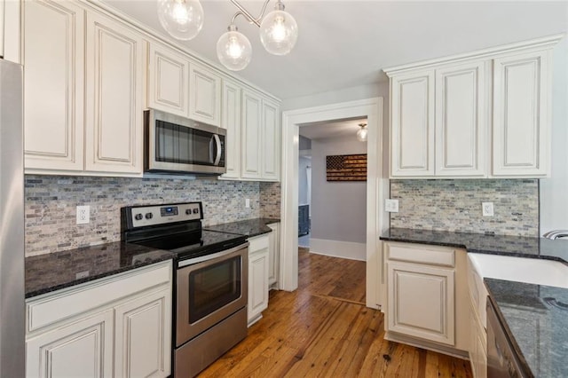 1382 6th Ave, Auburn, GA 30011 - kitchen with appliances with stainless steel finishes, light wood-type flooring, backsplash, and dark stone counters