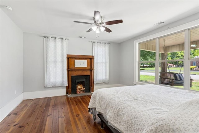 1382 6th Ave, Auburn, GA 30011 - bedroom with hardwood / wood-style floors, baseboards, a warm lit fireplace, and a ceiling fan