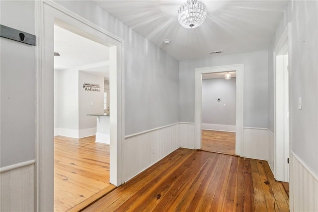 1382 6th Ave, Auburn, GA 30011 - corridor with wood-type flooring, a chandelier, and wainscoting