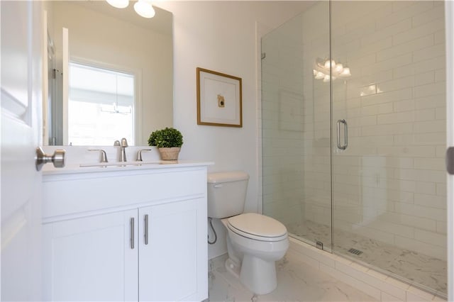 bathroom featuring vanity, toilet, and a shower with door