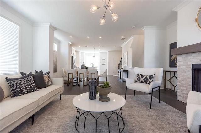 living room with a notable chandelier, dark hardwood / wood-style flooring, plenty of natural light, and a fireplace