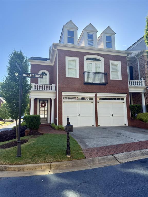 11715 Dancliff Trce, Alpharetta, GA 30009 - view of front facade with driveway, an attached garage, brick siding, and a front lawn