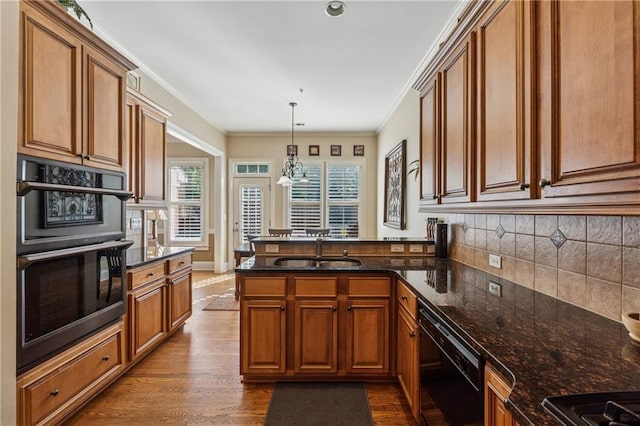 11715 Dancliff Trce, Alpharetta, GA 30009 - kitchen with a sink, black appliances, a peninsula, brown cabinetry, and backsplash