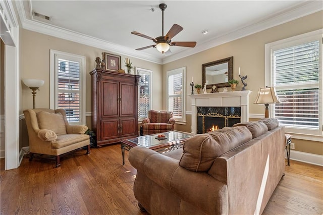 11715 Dancliff Trce, Alpharetta, GA 30009 - living area featuring ceiling fan, light wood-style floors, a fireplace, ornamental molding, and healthy amount of natural light