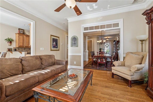 11715 Dancliff Trce, Alpharetta, GA 30009 - living area with crown molding, a chandelier, light wood finished floors, and a ceiling fan