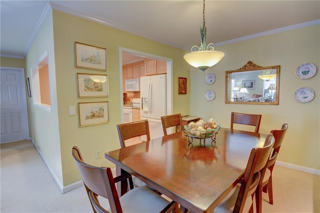 dining room featuring crown molding, light colored carpet, and baseboards