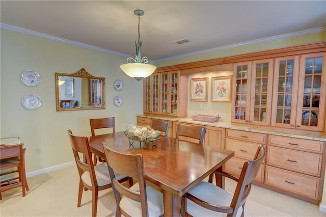 dining room featuring visible vents, light colored carpet, crown molding, and baseboards