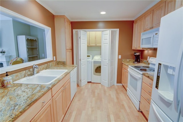 kitchen with washing machine and clothes dryer, light wood-type flooring, ornamental molding, white appliances, and a sink