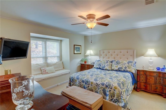 carpeted bedroom featuring visible vents, ceiling fan, and ornamental molding