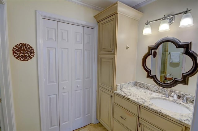 bathroom featuring a closet, tile patterned flooring, vanity, and ornamental molding