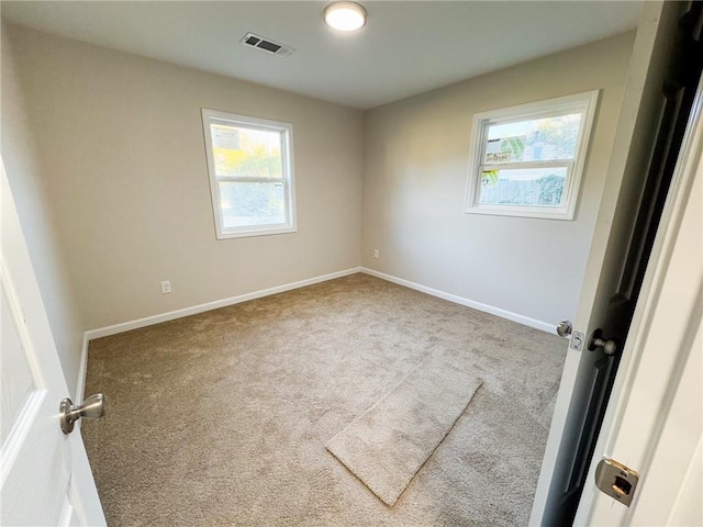 carpeted spare room featuring plenty of natural light