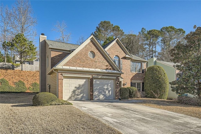 traditional home featuring brick siding, driveway, a chimney, and an attached garage