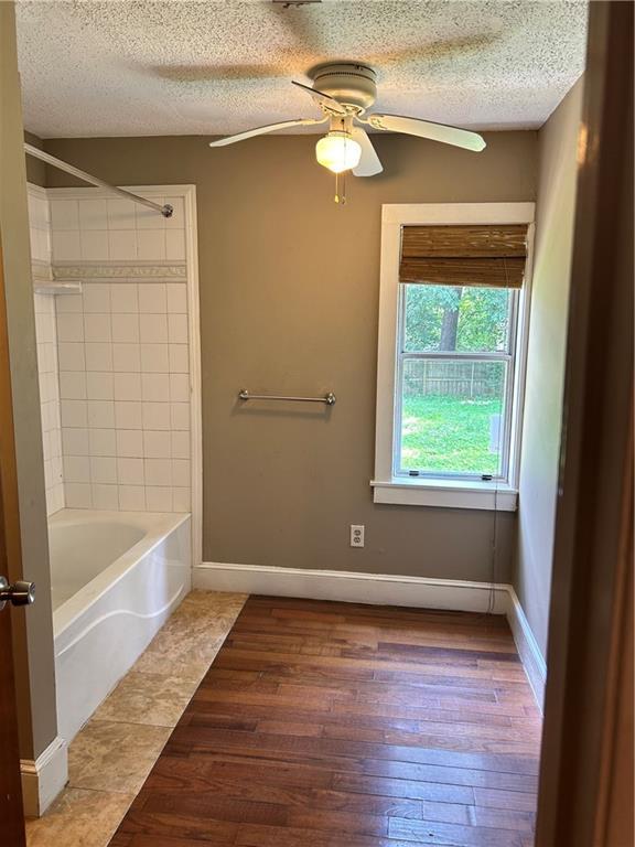 2203 Hillcrest Ave, Decatur, GA 30032 - bathroom with a textured ceiling, tiled shower / bath combo, hardwood / wood-style flooring, and ceiling fan
