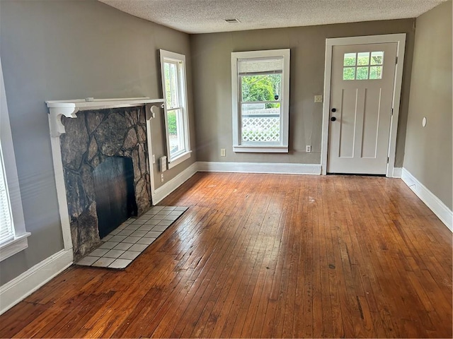 2203 Hillcrest Ave, Decatur, GA 30032 - unfurnished living room with a textured ceiling, a fireplace, and light hardwood / wood-style floors