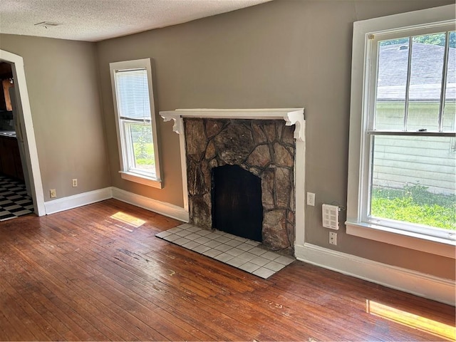 2203 Hillcrest Ave, Decatur, GA 30032 - unfurnished living room featuring a textured ceiling, hardwood / wood-style floors, and plenty of natural light