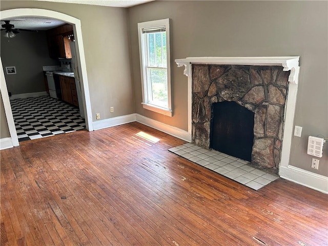 2203 Hillcrest Ave, Decatur, GA 30032 - unfurnished living room with ceiling fan, a stone fireplace, and light hardwood / wood-style flooring