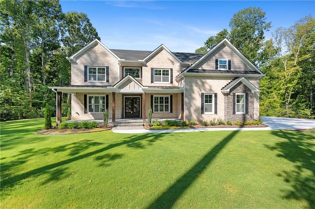 craftsman inspired home featuring covered porch and a front yard