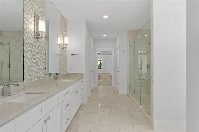 bathroom featuring a shower with door and vanity