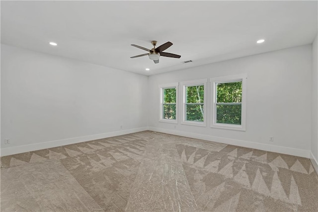 carpeted spare room featuring ceiling fan