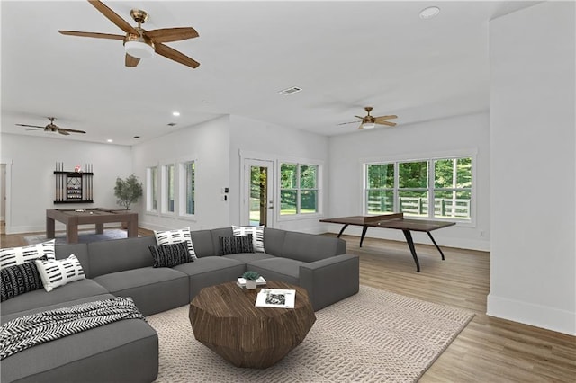 living room featuring light wood-type flooring and ceiling fan