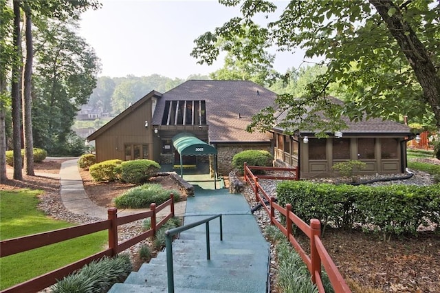 rear view of house with a playground and a sunroom