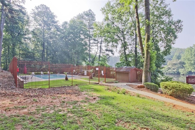 view of yard with a fenced in pool and a storage shed