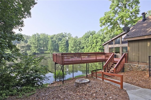 view of yard featuring a deck with water view and an outdoor fire pit