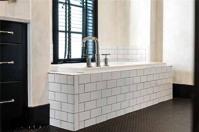 bathroom with tiled tub and tile patterned floors