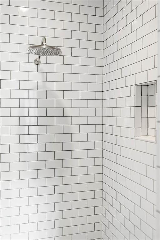 interior details featuring tiled shower